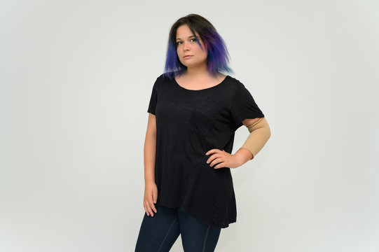 Stock Foto Portrait of a knee-deep funny cheerful girl of a young woman with multi-colored hair in a black T-shirt on a white background. In the studio, smiling, talking.