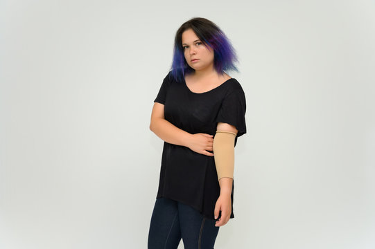 Stock Foto Portrait of a knee-deep funny cheerful girl of a young woman with multi-colored hair in a black T-shirt on a white background. In the studio, smiling, talking.
