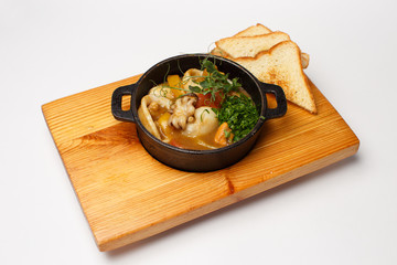 sea food soup in a pan on a wood