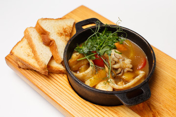 sea food soup in a pan on a wood