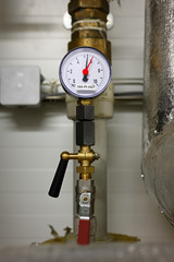 Analog pressure indicator circular on pipe.