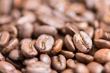 Coffee beans on a plate placed on a wooden table.