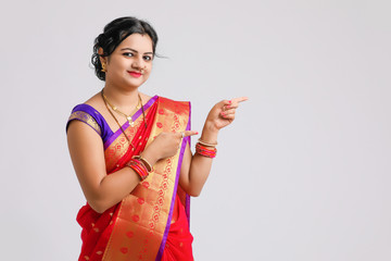 Happy Young woman wearing sari and showing direction with hand