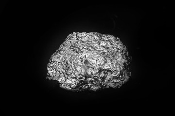 Aluminum stone on isolated black background. Aluminum is a chemical element, at room temperature it...