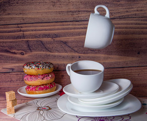 flying food tea drinking donut in the air on a wooden background with colored sprinkling cake cheesecake with fresh berries strawberries