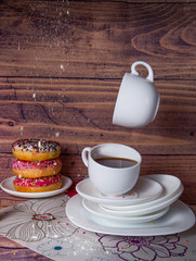 flying food tea drinking donut in the air on a wooden background with colored sprinkling cake cheesecake with fresh berries strawberries