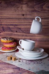 flying food tea drinking donut in the air on a wooden background with colored sprinkling cake cheesecake with fresh berries strawberries
