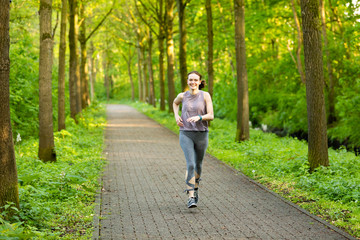young woman runs in a forest and makes fitness