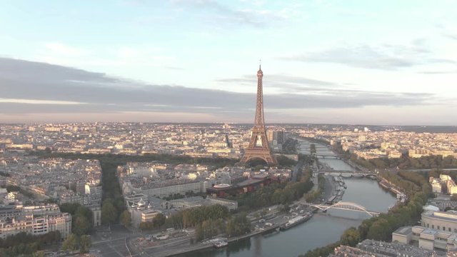 Aerial drone shot of the famous Eiffel Tower in Paris, France while sunrise with the Seine River in the foreground