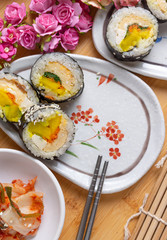 Kimchi and Gimbap serving on white plate