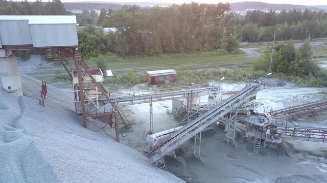 outdated large white mining construction on concrete support in grey rubble barrow aerial view. Concept environmental change