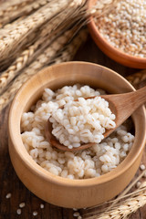 Cooked peeled barley grains in wooden bowl