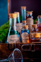 Obraz na płótnie Canvas Potions, mixtures, and remedies for inspiration, motivation and productive work close-up. Handwritten potion label. Self-care concept.