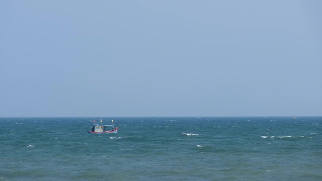 The fishing boat swayed at sea with wind, big wave. Royalty high quality free stock video footage of the small wooden fishing swaying on the blue sea, fishing boat is push off