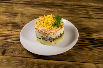Traditional russian salad Mimosa on wooden table