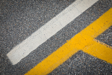 Fototapeta premium yellow and white lines on the road, traffic signs on asphalt, cracked street with lines