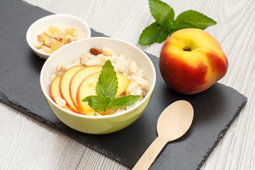 Sorghum salad with nuts and fresh peach on stone board.