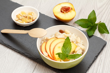 Sorghum salad with nuts and fresh peach on stone board.