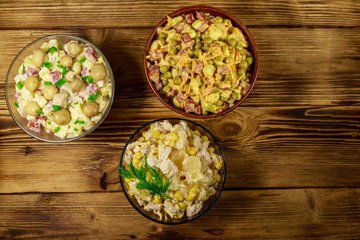 Set of festive mayonnaise salads on wooden table. Top view