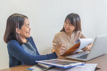 Two smiling women having happy conversation at business workplace