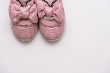 On a white background, pink baby sneakers, copy space