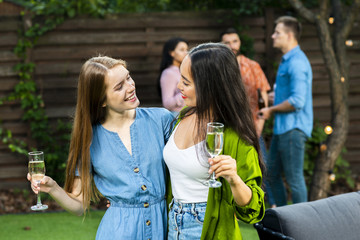 Pretty young girls with drinks looking at each other