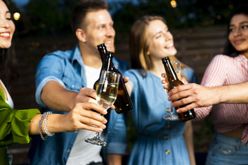 Young people toasting beer bottles