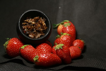 bowl with tobacco for hookah. berries on a black background. smoking sheesha