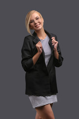 Woman, a teacher in a jacket and glasses on a gray background, expresses emotions. Copy space.