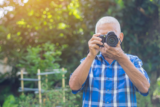Senior man using a camera to take photo