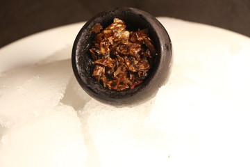 bowl with tobacco for hookah. berries on a black background