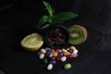 bowl with tobacco for hookah. berries on a black background