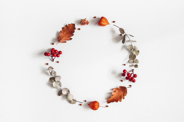 Autumn composition. Wreath made of dried flowers, eucalyptus leaves, berries on gray background. Autumn, fall, thanksgiving day concept. Flat lay, top view, copy space