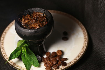 bowl with tobacco for hookah. fruits on a black background. smoking hookah