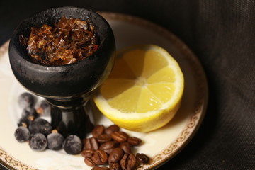 bowl with tobacco for hookah. fruits on a black background