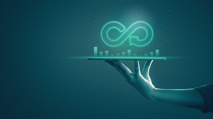 Circular economy with infinite concept. Business man showing arrow infinity symbol with neon light and dark background. Graph showing the earnings, profits of business shares in good feedback.