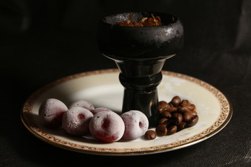bowl with tobacco for hookah. berries on a black background