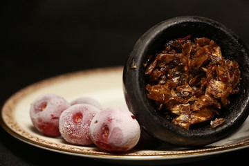 bowl with tobacco for hookah. berries on a black background