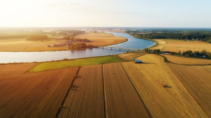Aerial view on the field during sunset. Landscape from drone. Agricultural landscape from air. Beautiful river and sunlight. Finland