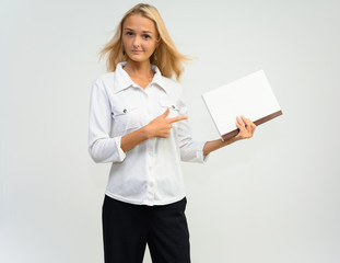 Studio portrait of a pretty blonde student girl, young woman in a white shirt on a white background. Talking, showing emotions.