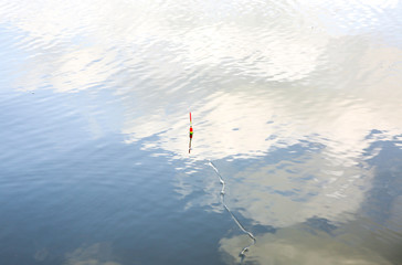 Fishing float in the water. Bobber in the lake. Outdoors hobby in the nature.