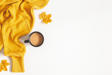 Fototapeta premium Autumn composition. Cup of coffee, yellow sweater on white background. Autumn, fall concept. Flat lay, top view, copy space
