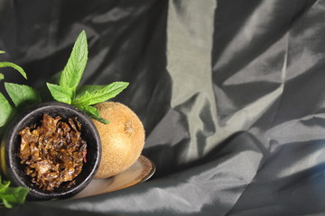 bowl with tobacco for hookah. berries on a black background