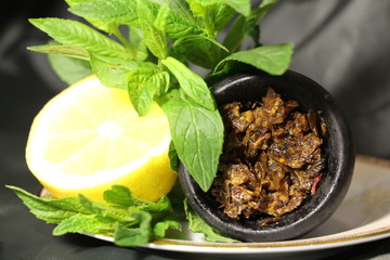 bowl with tobacco for hookah. fruits and berries on a black background. smoke hookah
