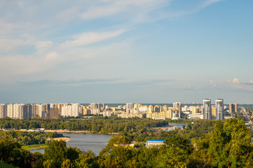 View of the city of Kiev, the Dnieper River. City panorama with a place across the river, park, summer day.