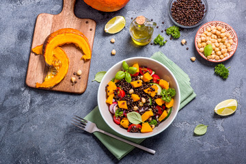 Healthy salad with roasted pumpkin, chickpeas and black lentils, autumn food, vegan eating