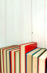 close up red novel book extends  the background is a white wood wall.