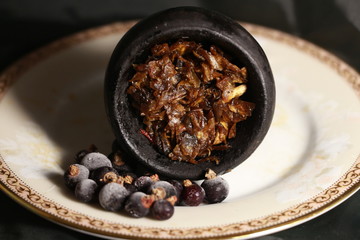 bowl with tobacco for hookah. berries on a black background