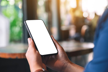 Mockup image of hands holding black mobile phone with blank desktop screen