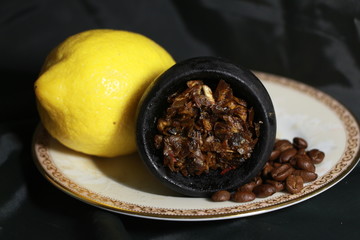 bowl with tobacco for hookah. fruits on a black background. smoke hookah